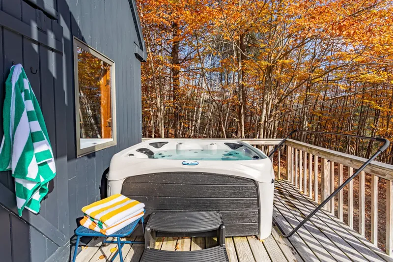 Hot tub on lower deck with fall foliage surrounding the property