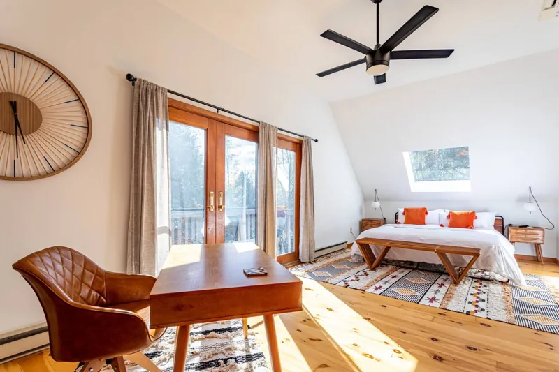 Upper king bedroom with French doors to private balcony, desk, and ceiling fan