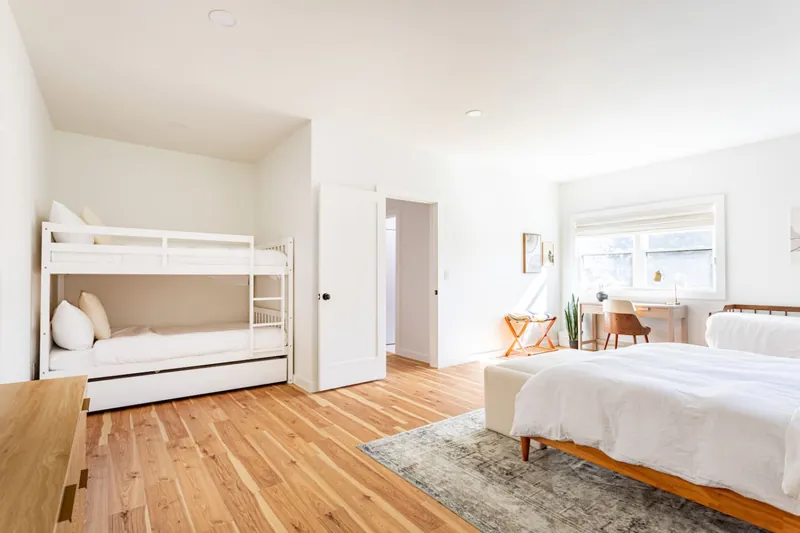 Bedroom with twin-over-twin bunk bed with trundle and queen bed, desk workspace