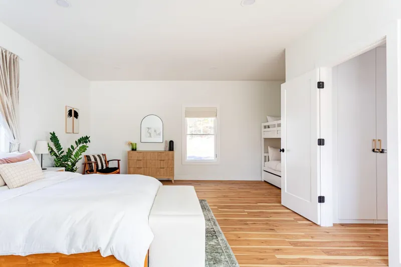 Bedroom showing queen bed and bunk nook, hardwood floors