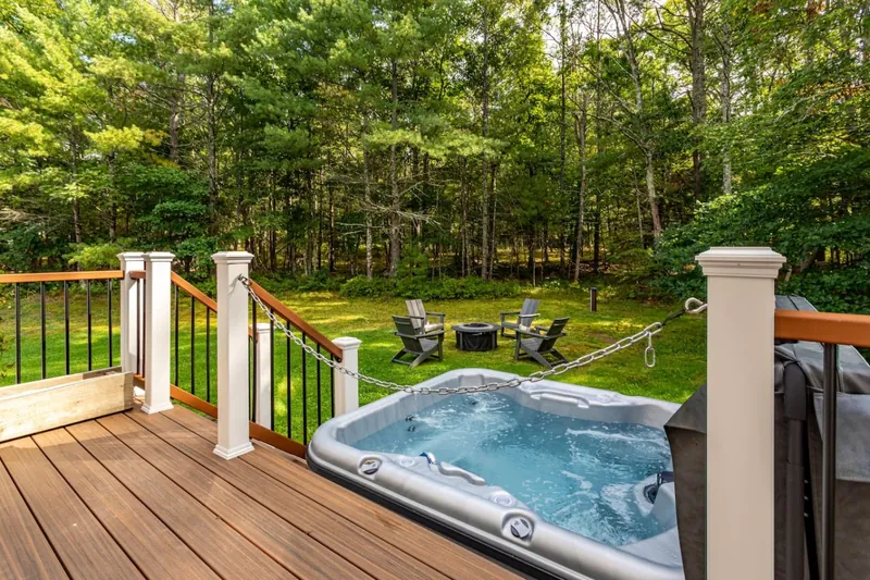 Private hot tub on the back deck, fire pit and woods beyond