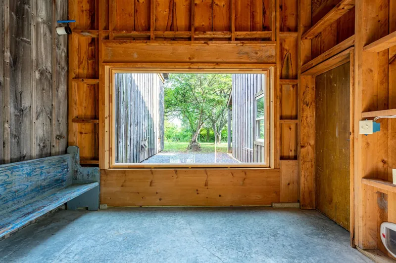Garden View Retreat: Expansive window framing lush greenery invites nature inside!