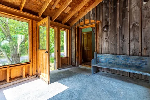 Entrance Hall: Bright and inviting with rustic wood accents and charming nature views!