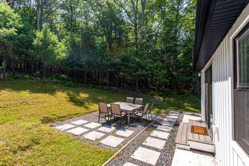 Outdoor Dining Haven: Embrace nature over a meal at this serene patio surrounded by greenery!