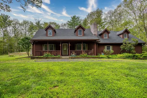 Charming country cabin surrounded by lush greenery, offering a peaceful family retreat.