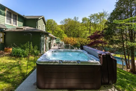 Outdoor Retreat: Soak in the hot tub while surrounded by lush greenery and a serene atmosphere!