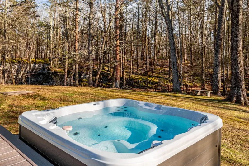 Hot tub on the deck with wooded creek backdrop