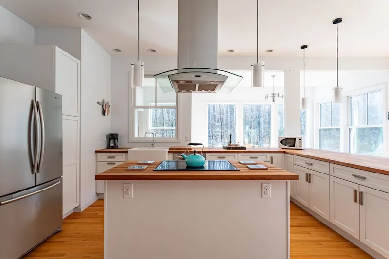 Kitchen with center island, induction cooktop, and range hood