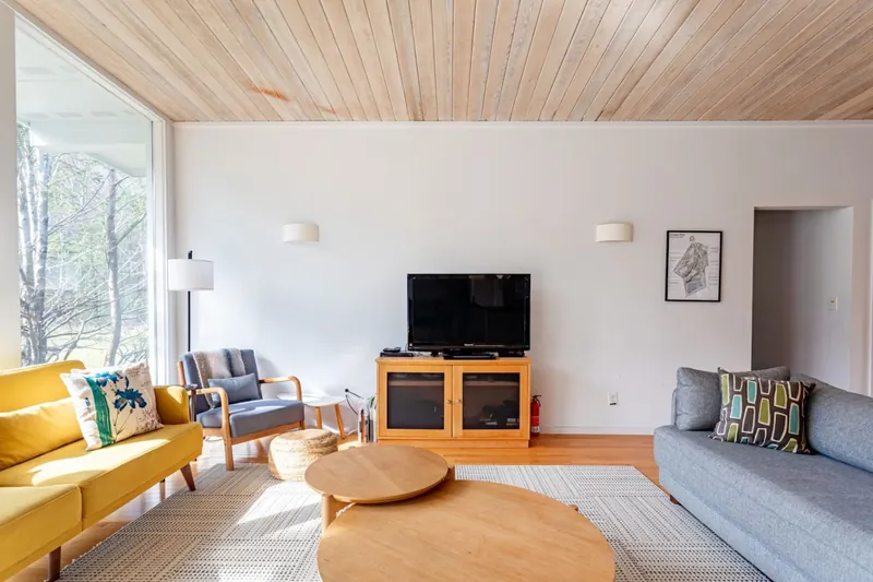 Living room with floor-to-ceiling windows overlooking the yard